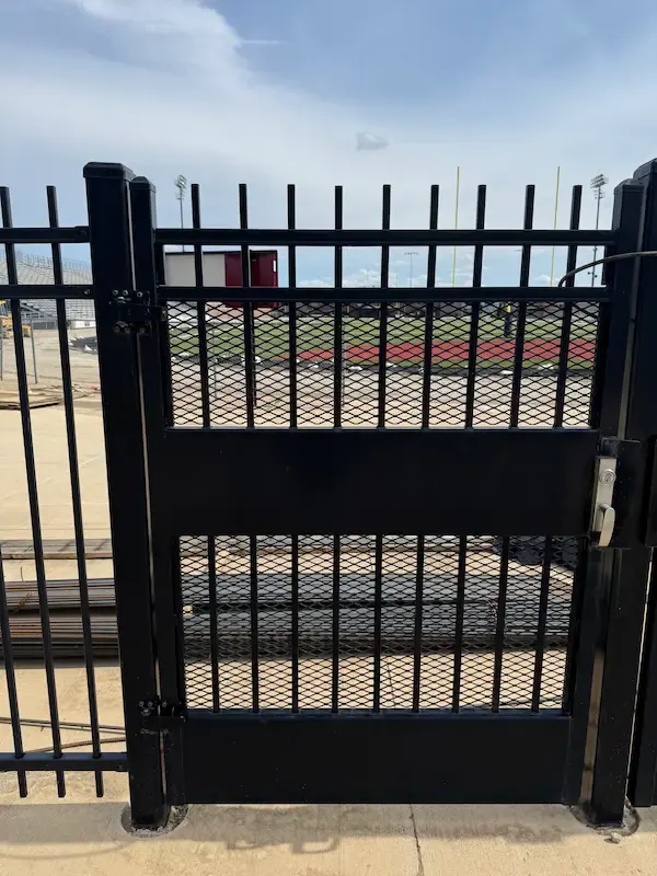 Black steel security gate with expanded-metal mesh panels