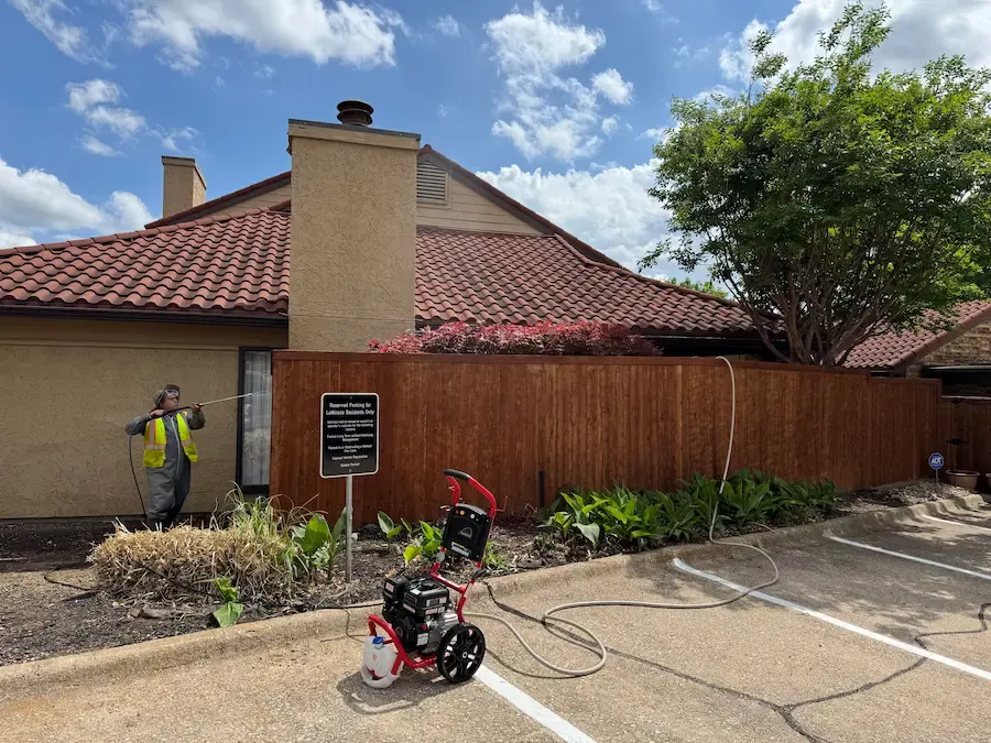 Pressure washing a wood privacy fence before refinishing